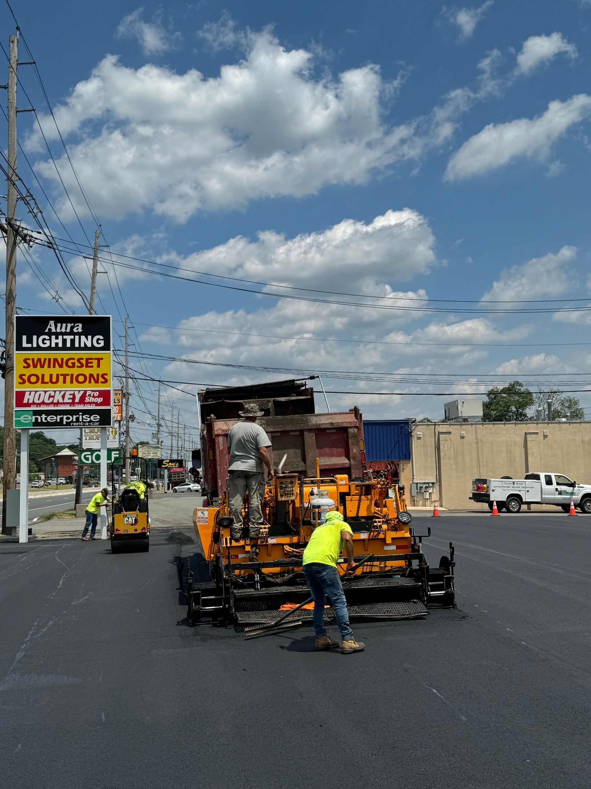 A sign that says asphalt solutions is on the side of the road