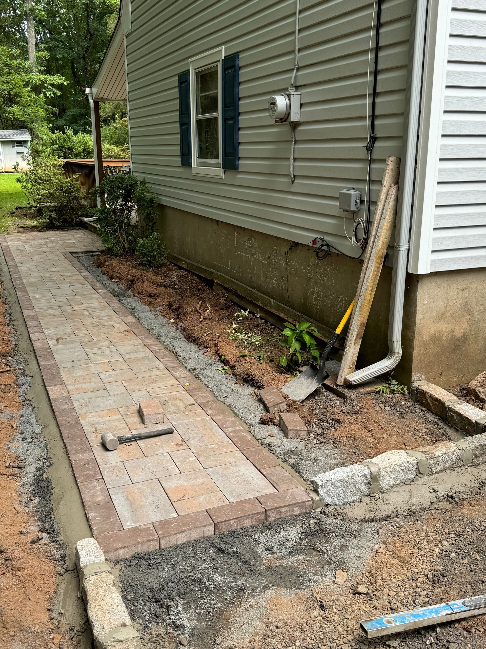 A sidewalk is being built in front of a house.