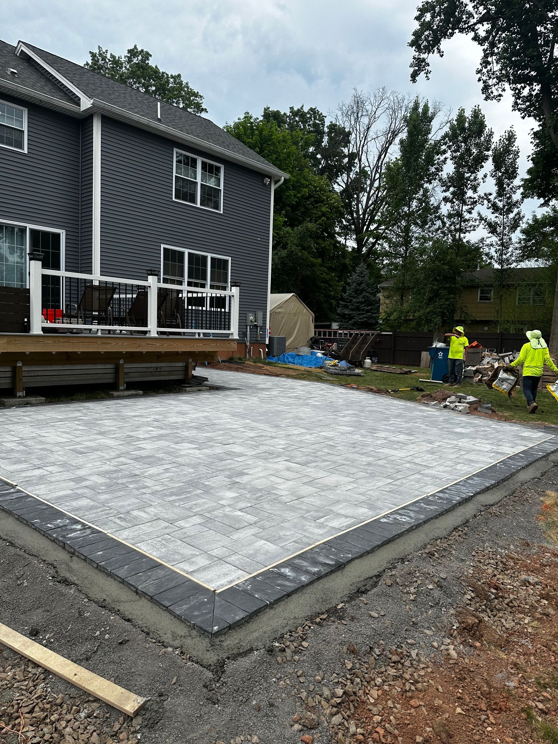 A concrete patio is being built in front of a house.