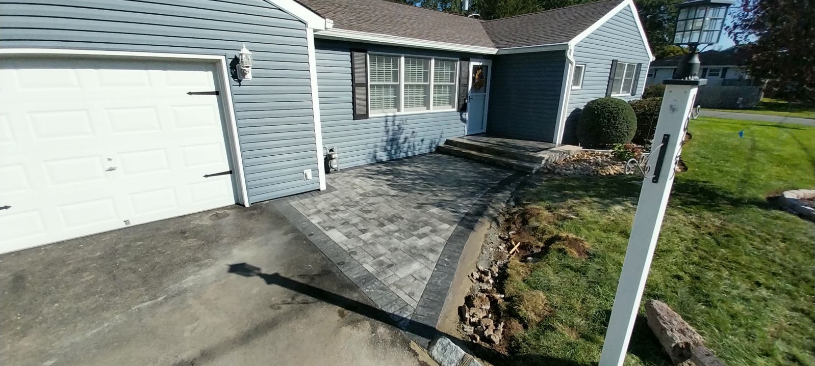 A house with a driveway and a mailbox in front of it.