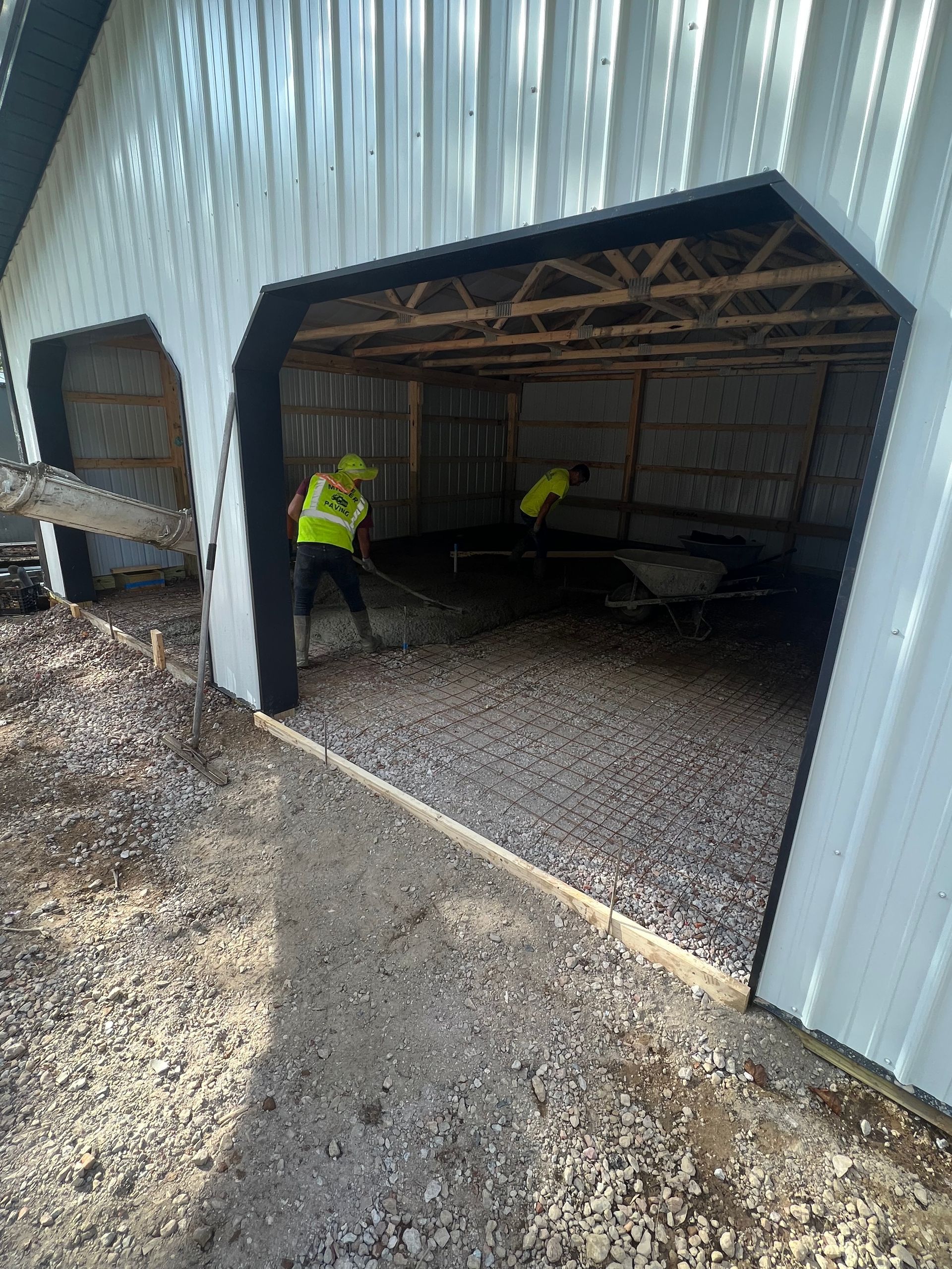 A man is shoveling gravel into a garage door.