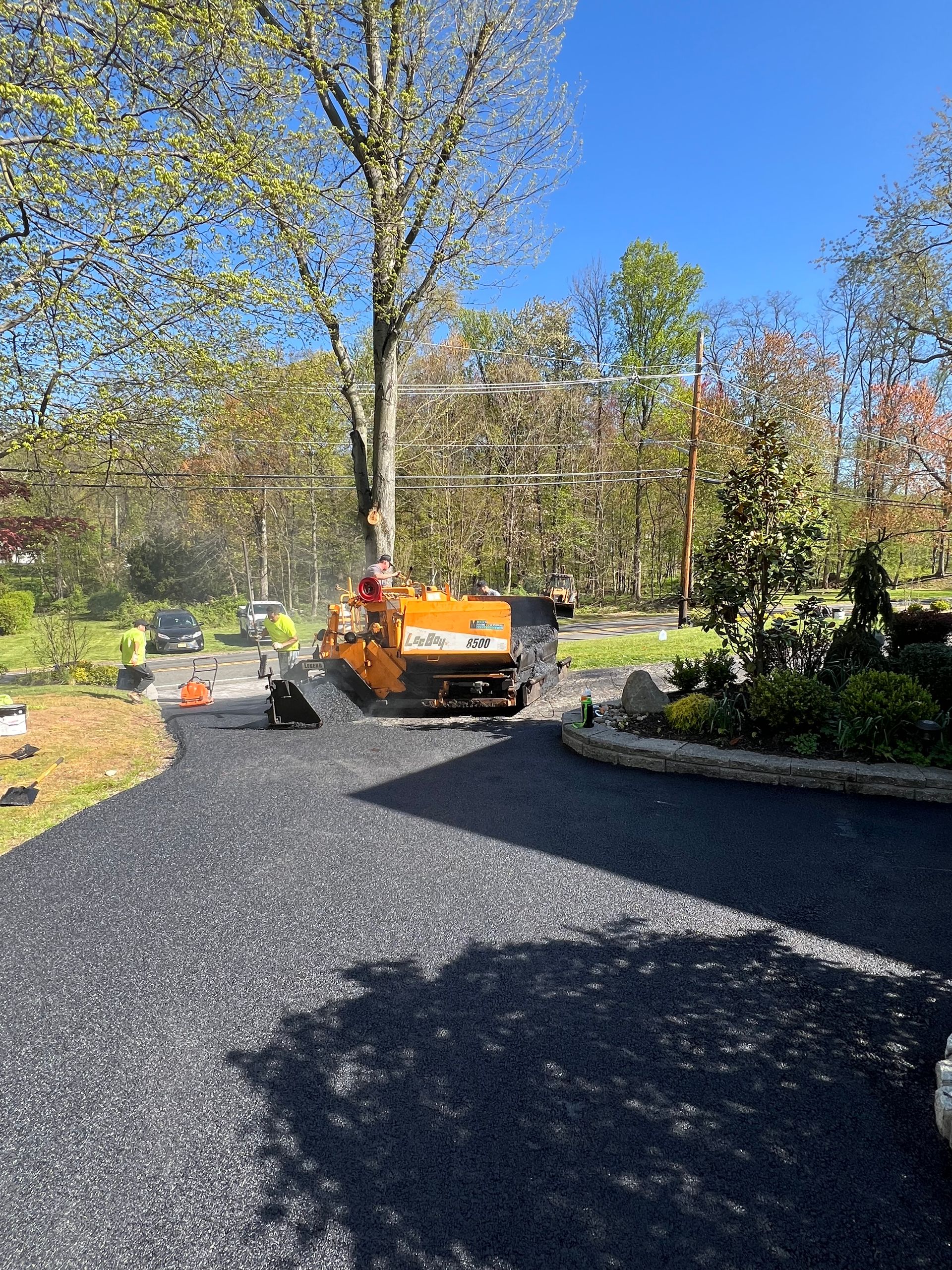 A machine is laying asphalt on a driveway.