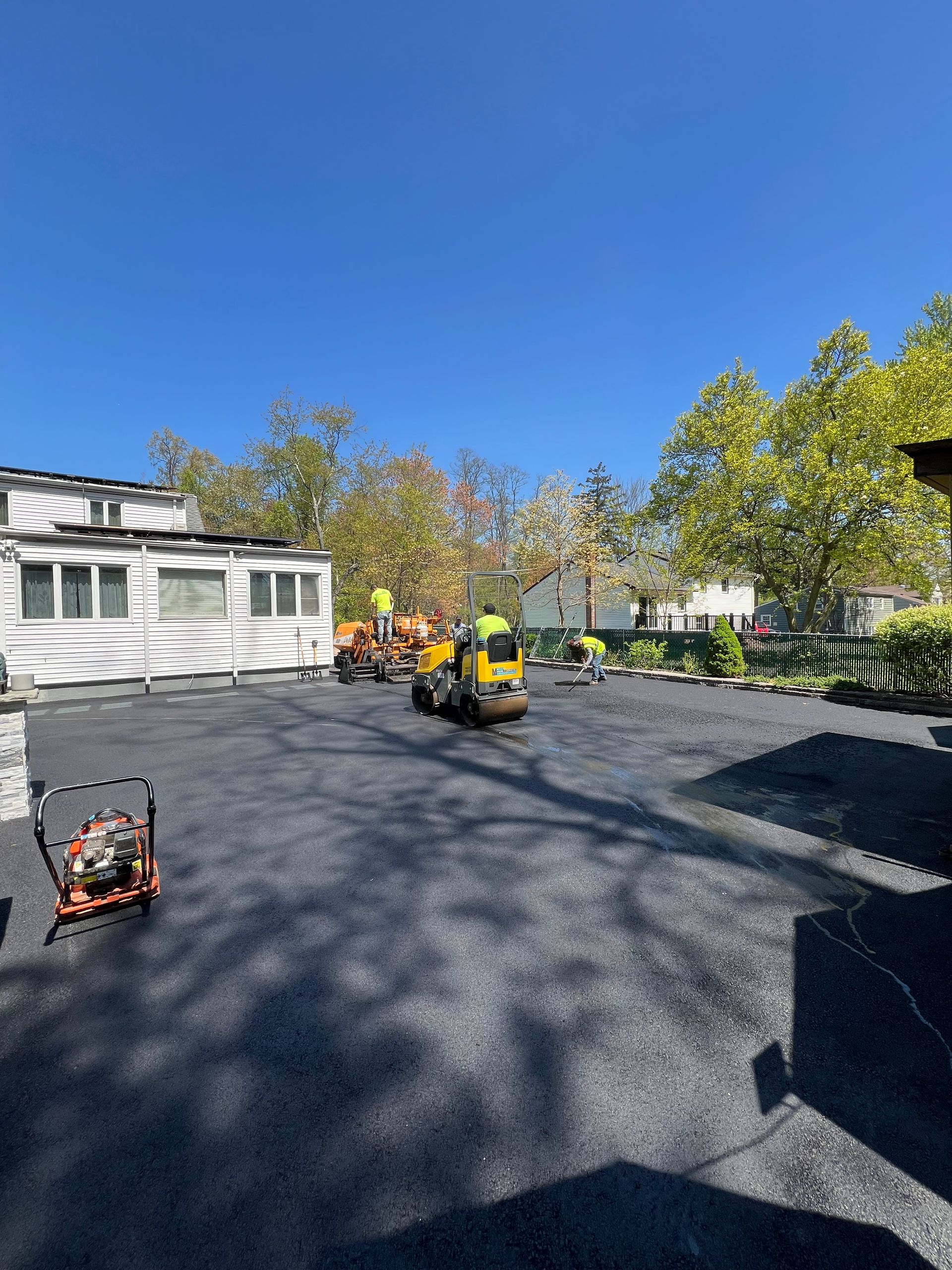 A lot of vehicles are parked in a parking lot in front of a house.