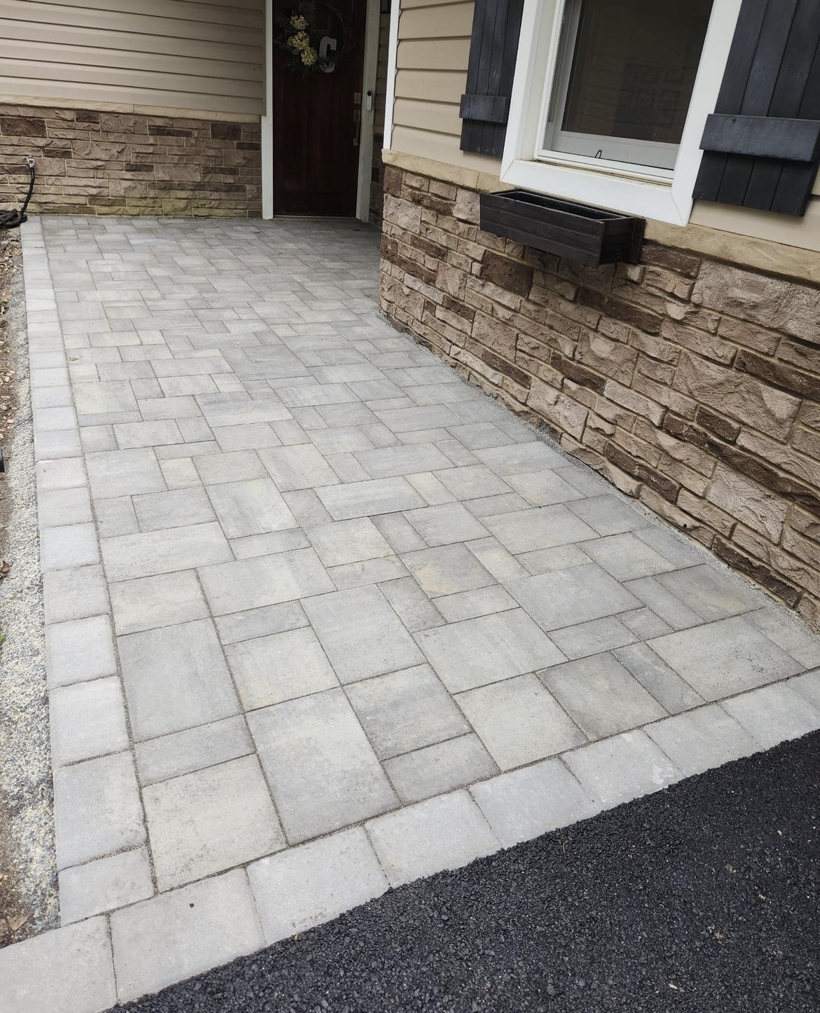 A brick walkway leading to the front door of a house.
