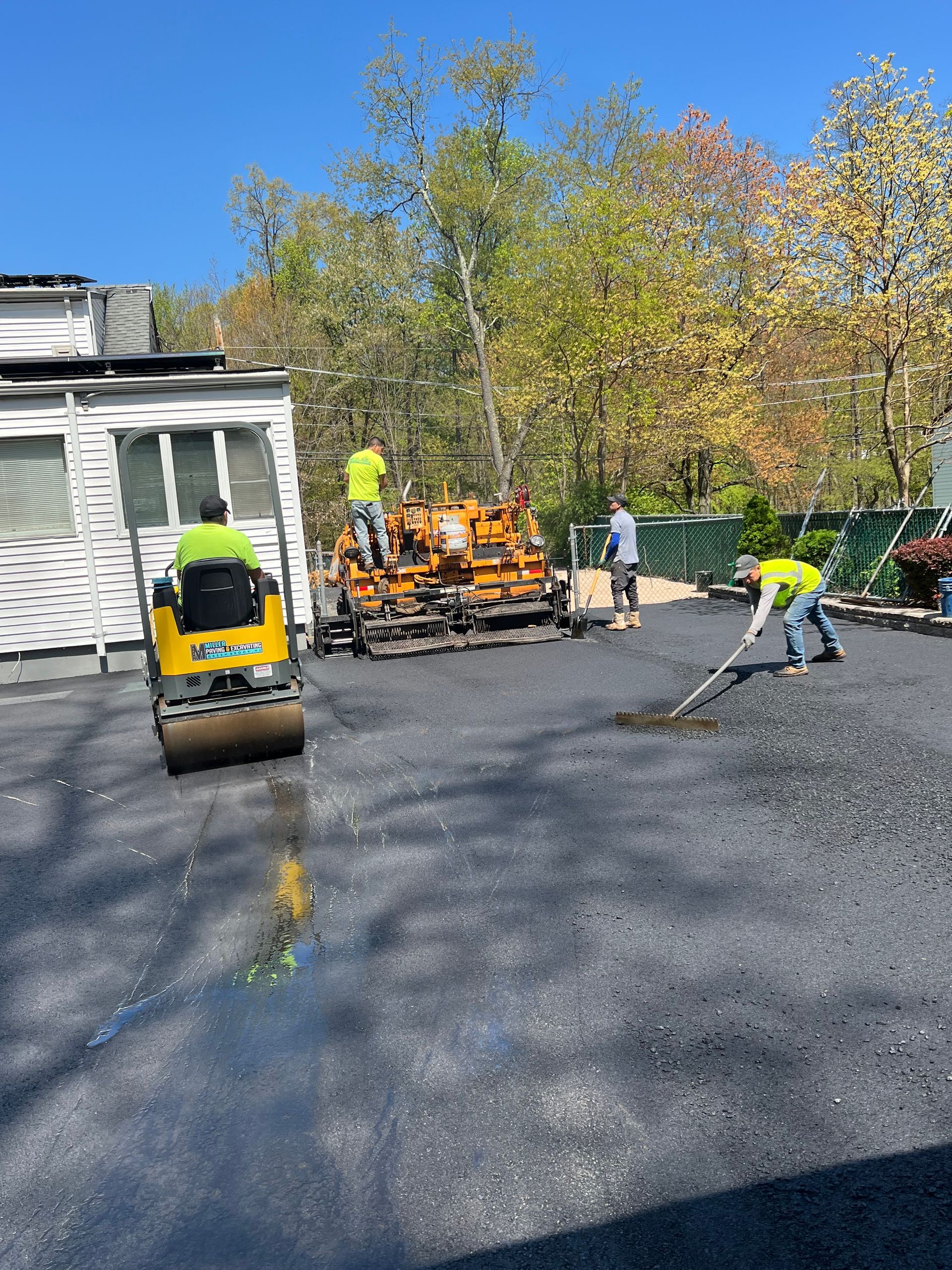 A group of construction workers are working on a driveway.