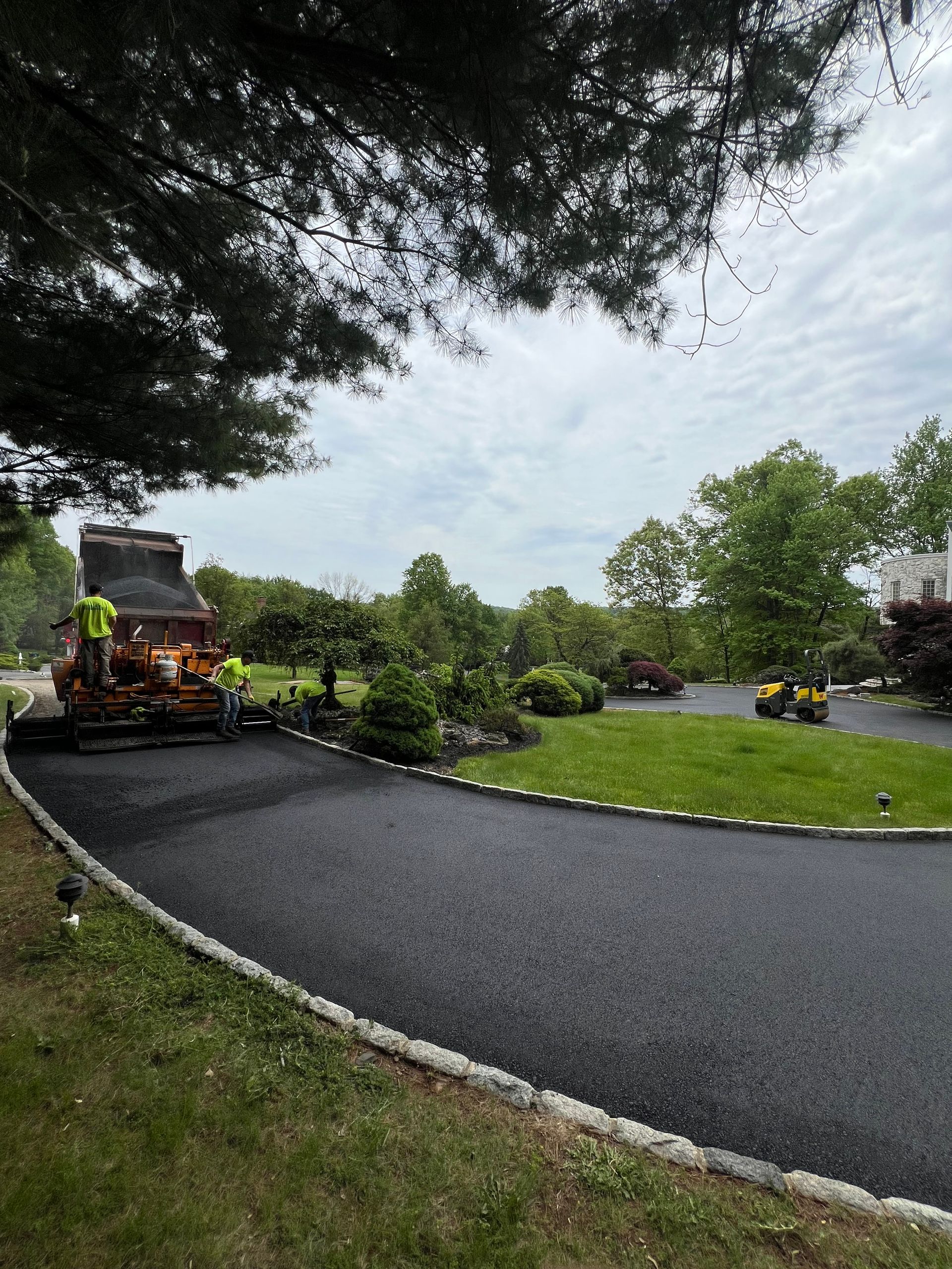A driveway is being paved in a residential area.