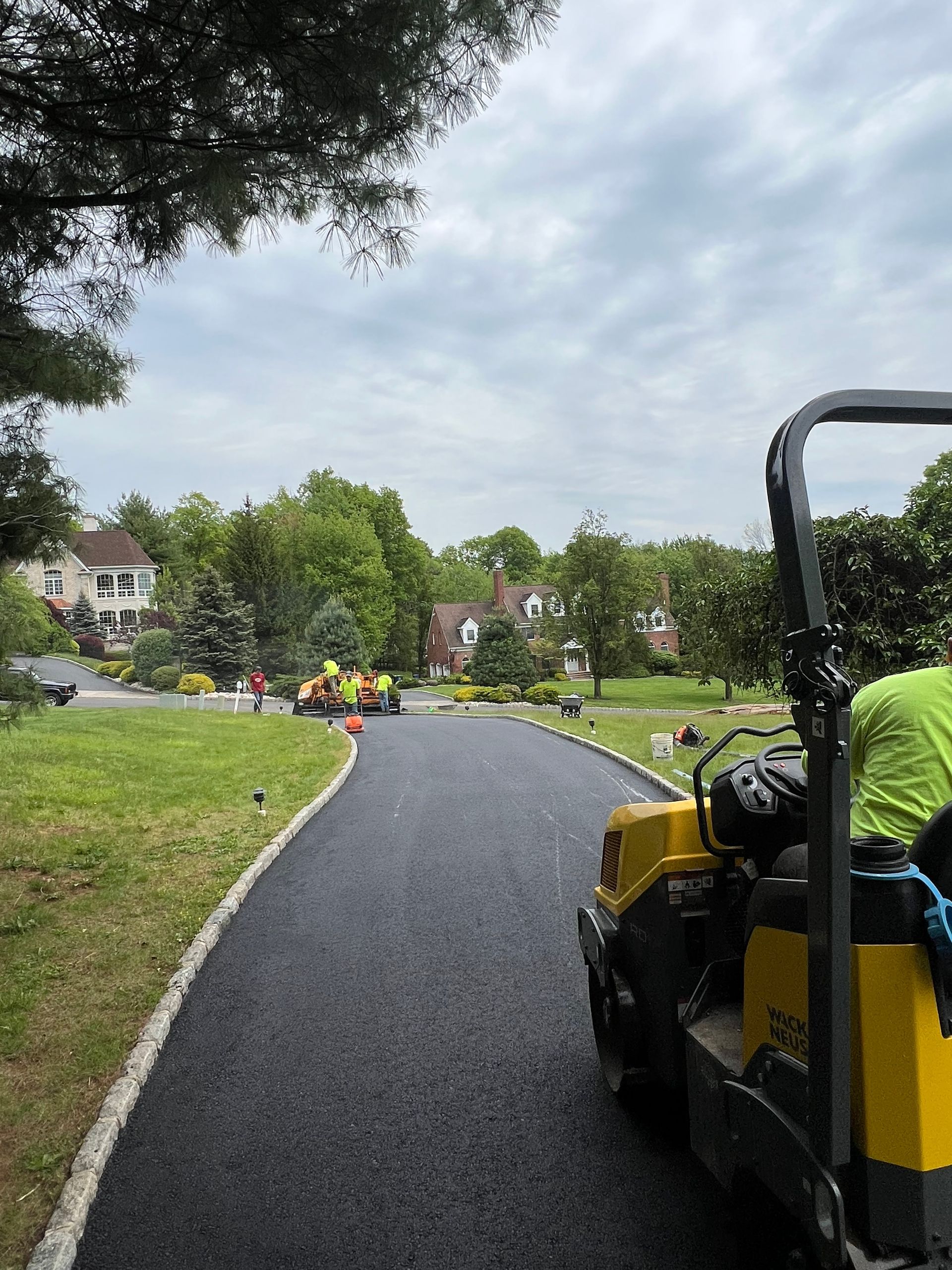 A man is driving a yellow truck down a road.