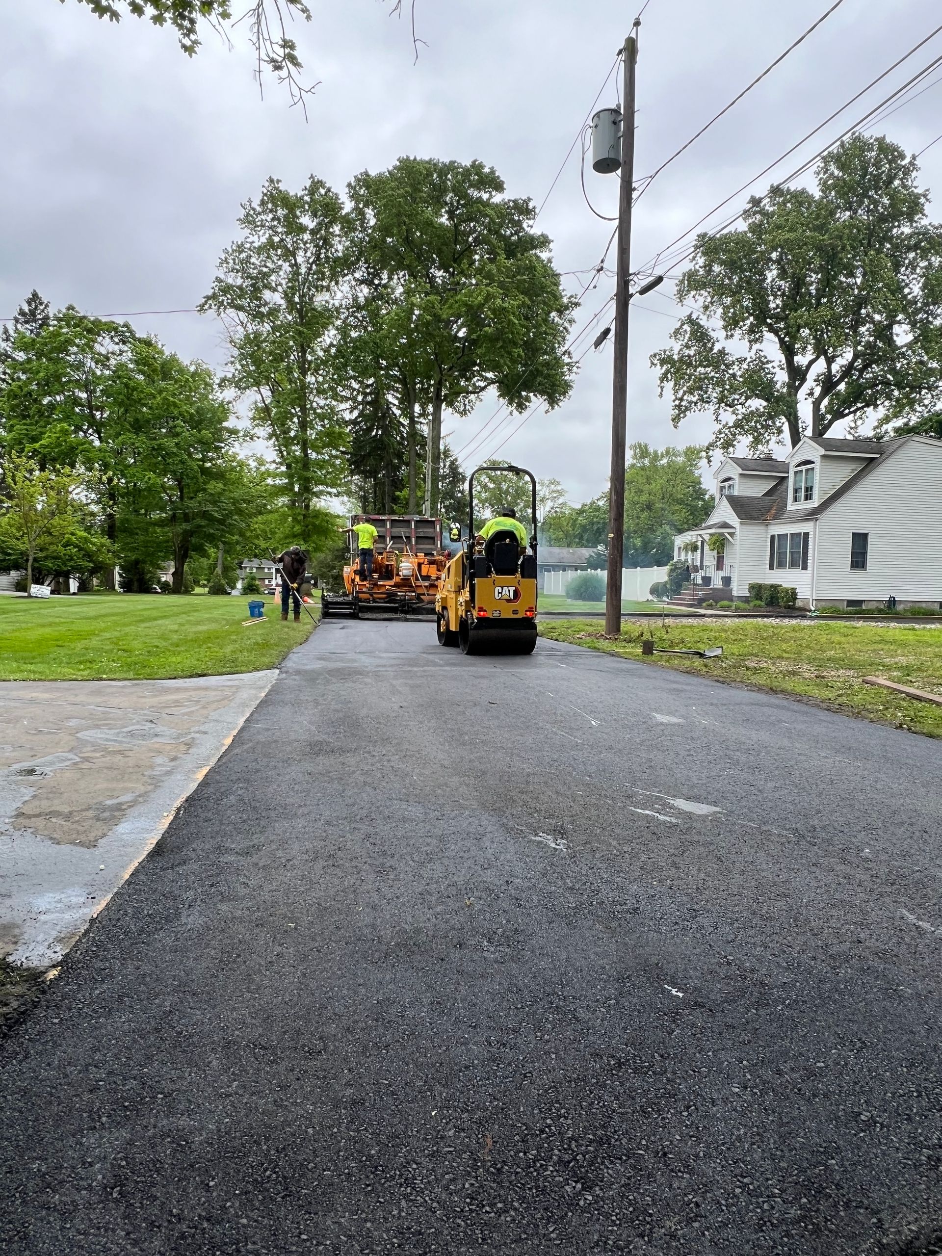 A group of construction vehicles are working on a road.