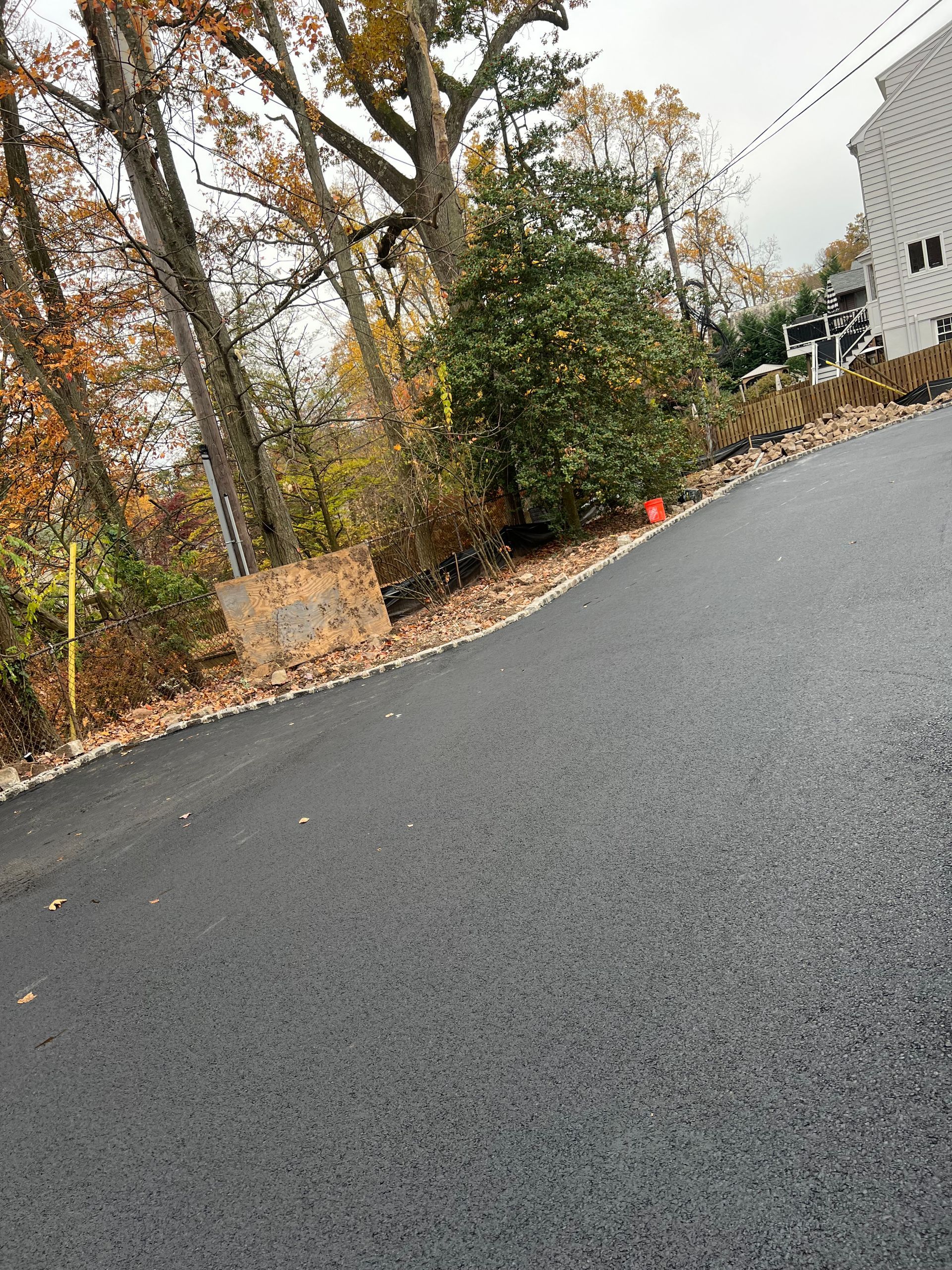 A road with trees on the side of it and a building in the background.