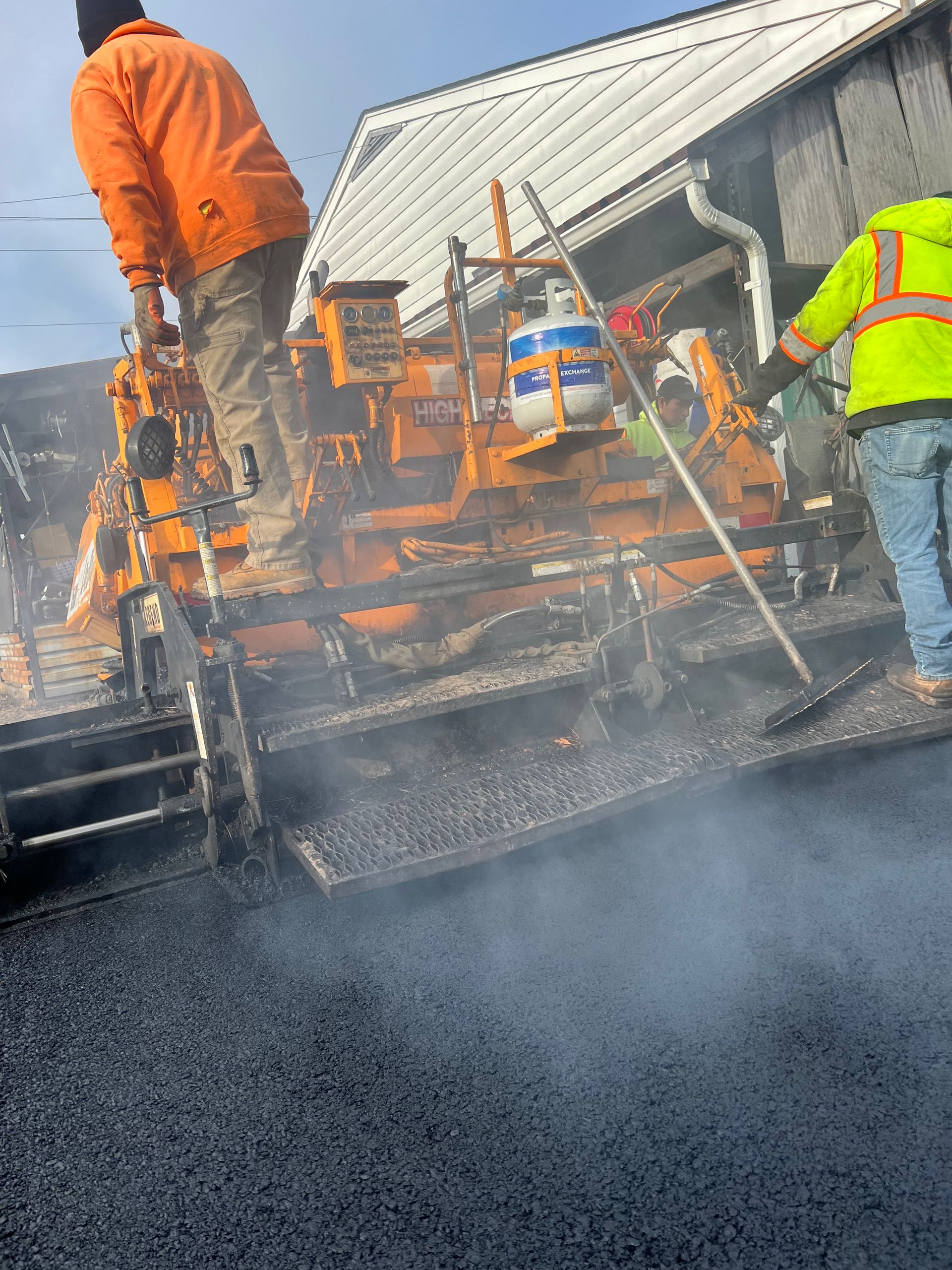 A group of construction workers are working on a road.