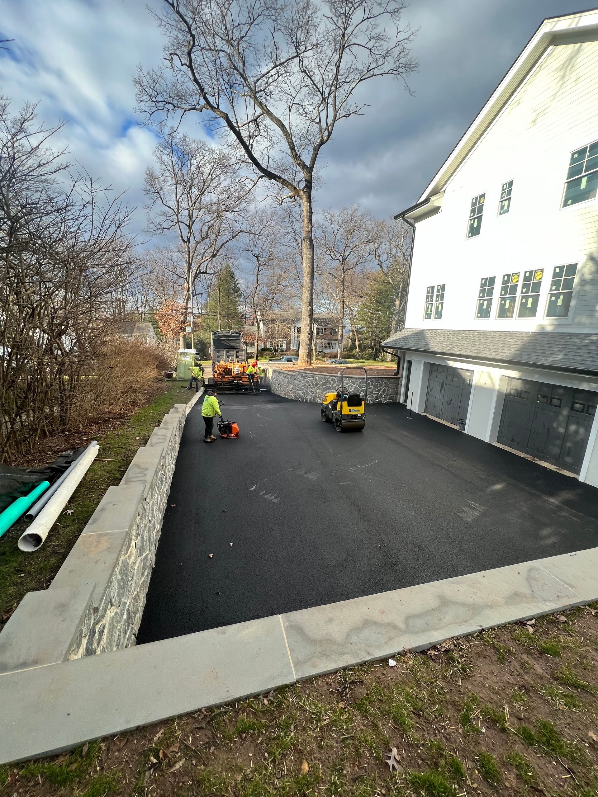 A large white building with a black driveway in front of it.