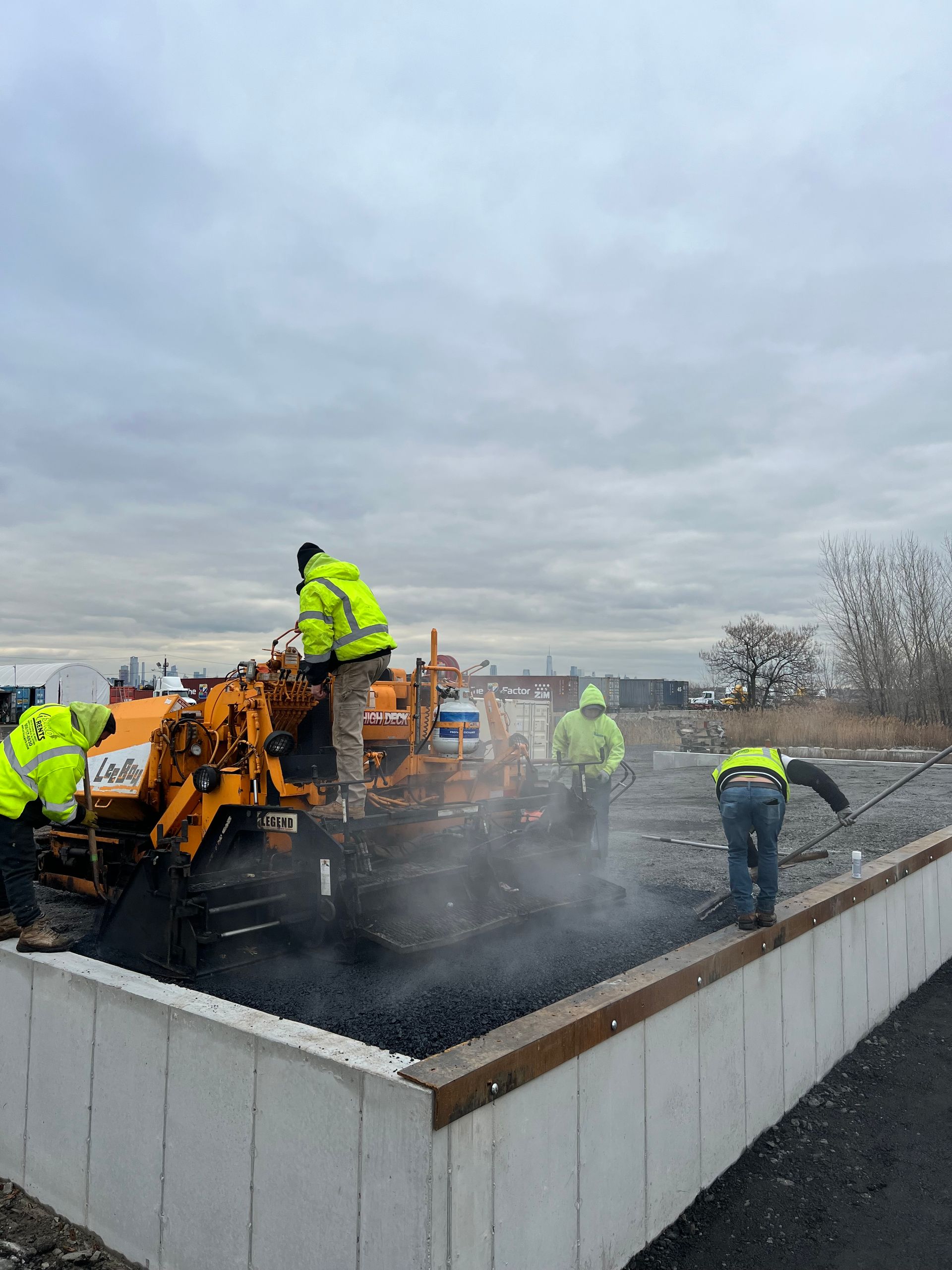 A group of construction workers are working on a road.