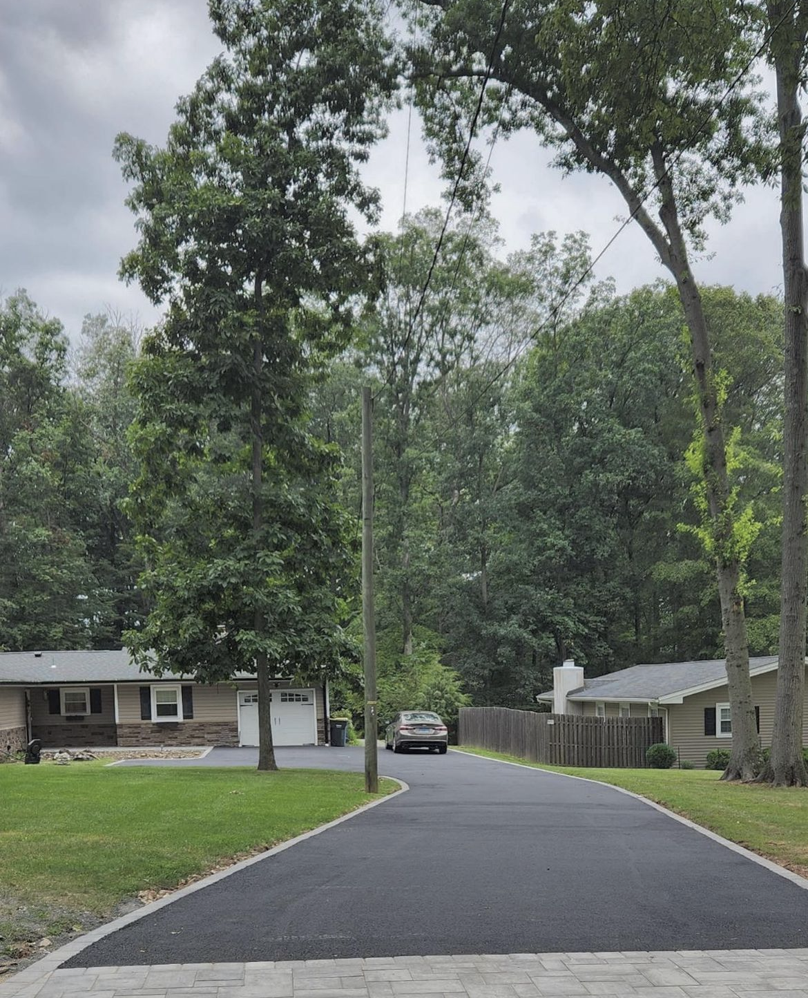 A car is driving down a driveway in a residential area