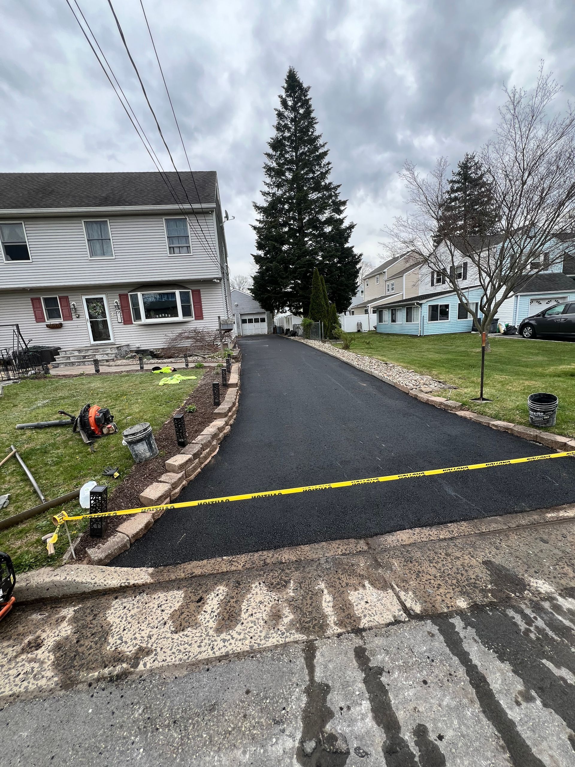 A driveway is being paved in front of a house.