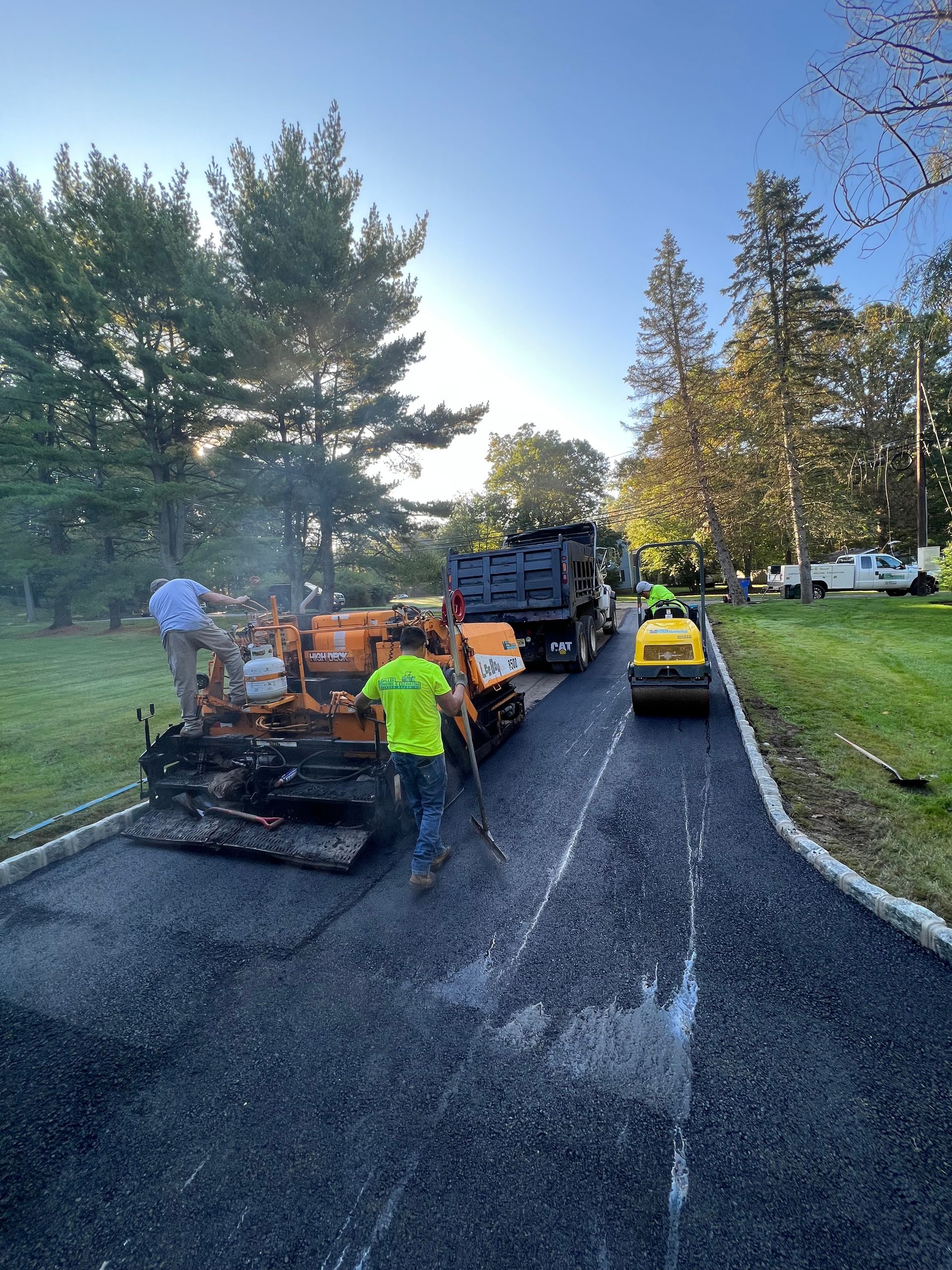 A group of people are working on a driveway.