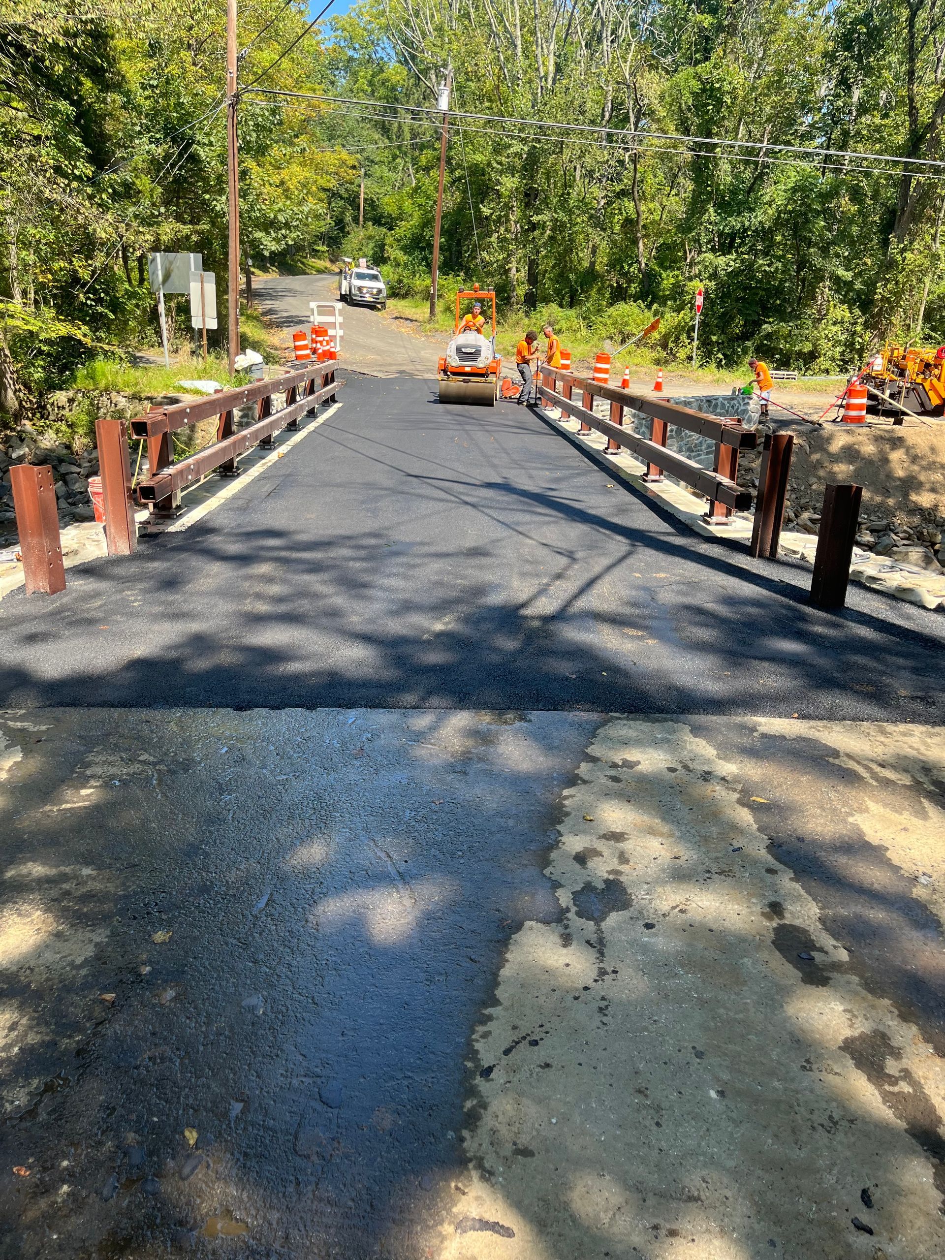 A bridge is being built on a road in the woods.