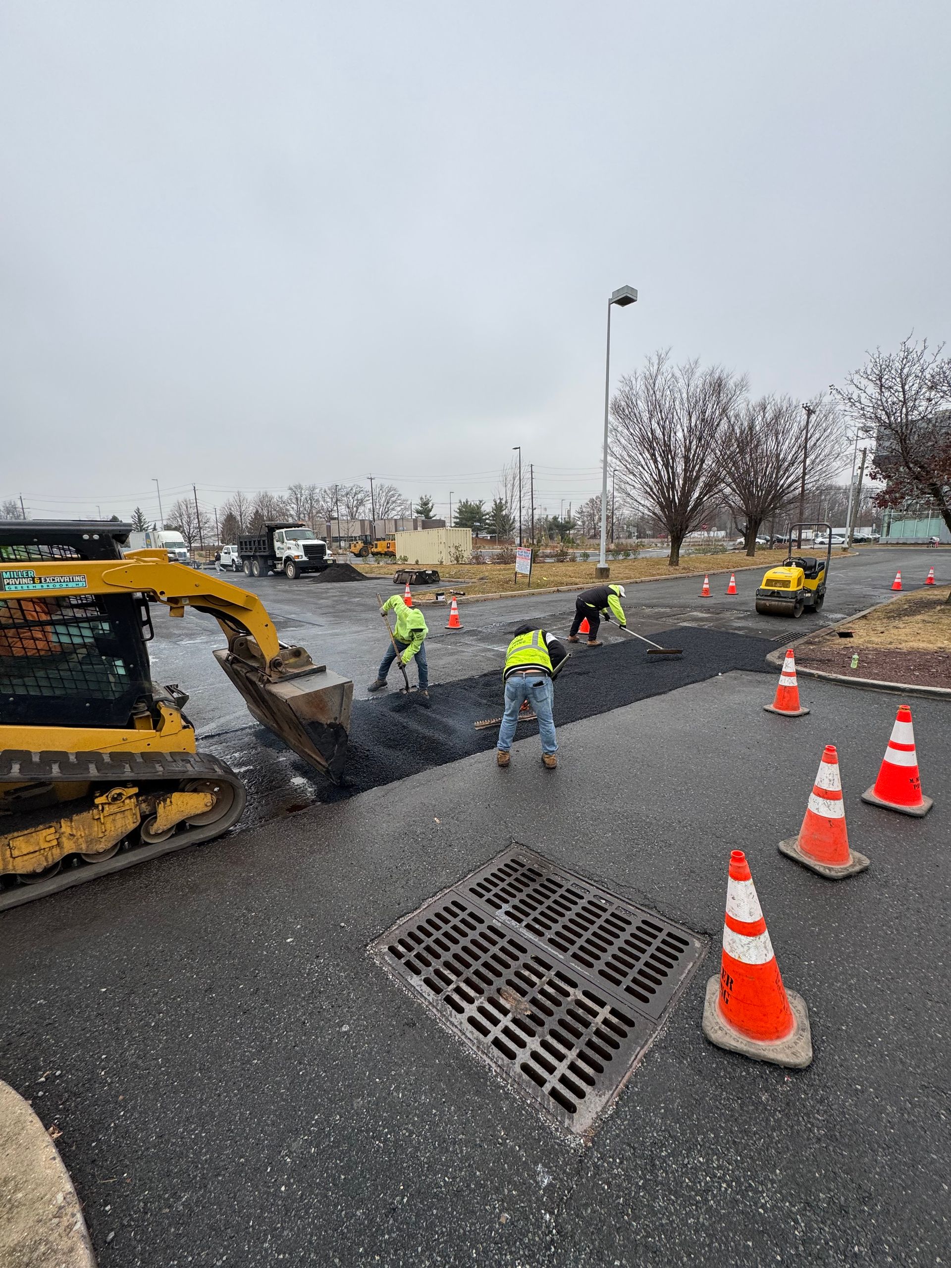A group of construction workers are working on a road.
