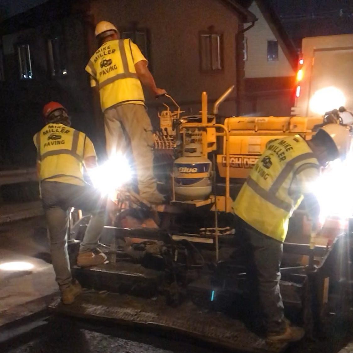 A group of construction workers wearing yellow vests and hard hats