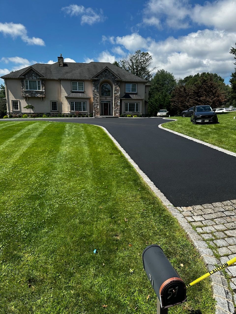 A large house with a driveway and a mailbox in front of it
