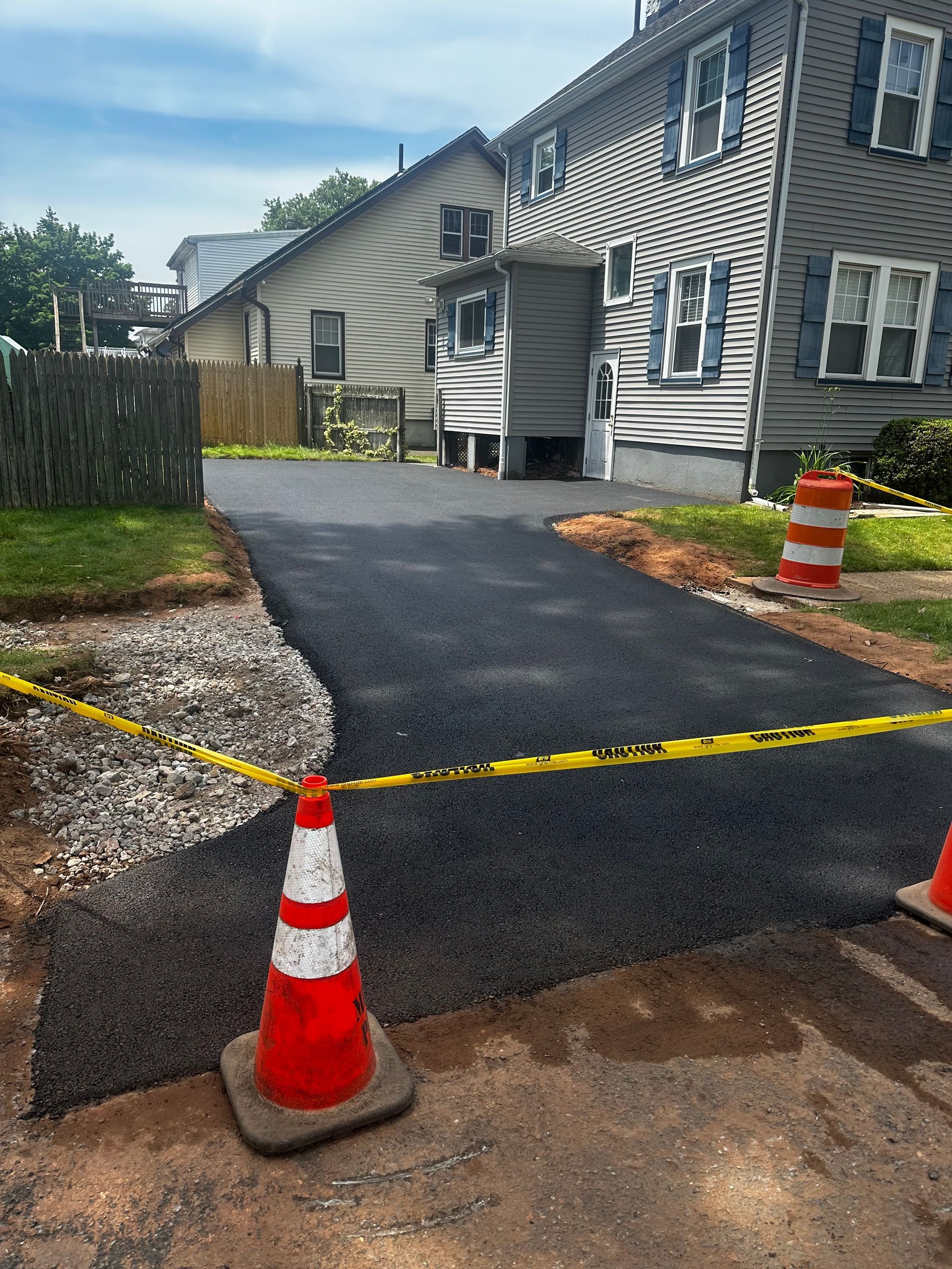 A driveway is being paved in front of a house