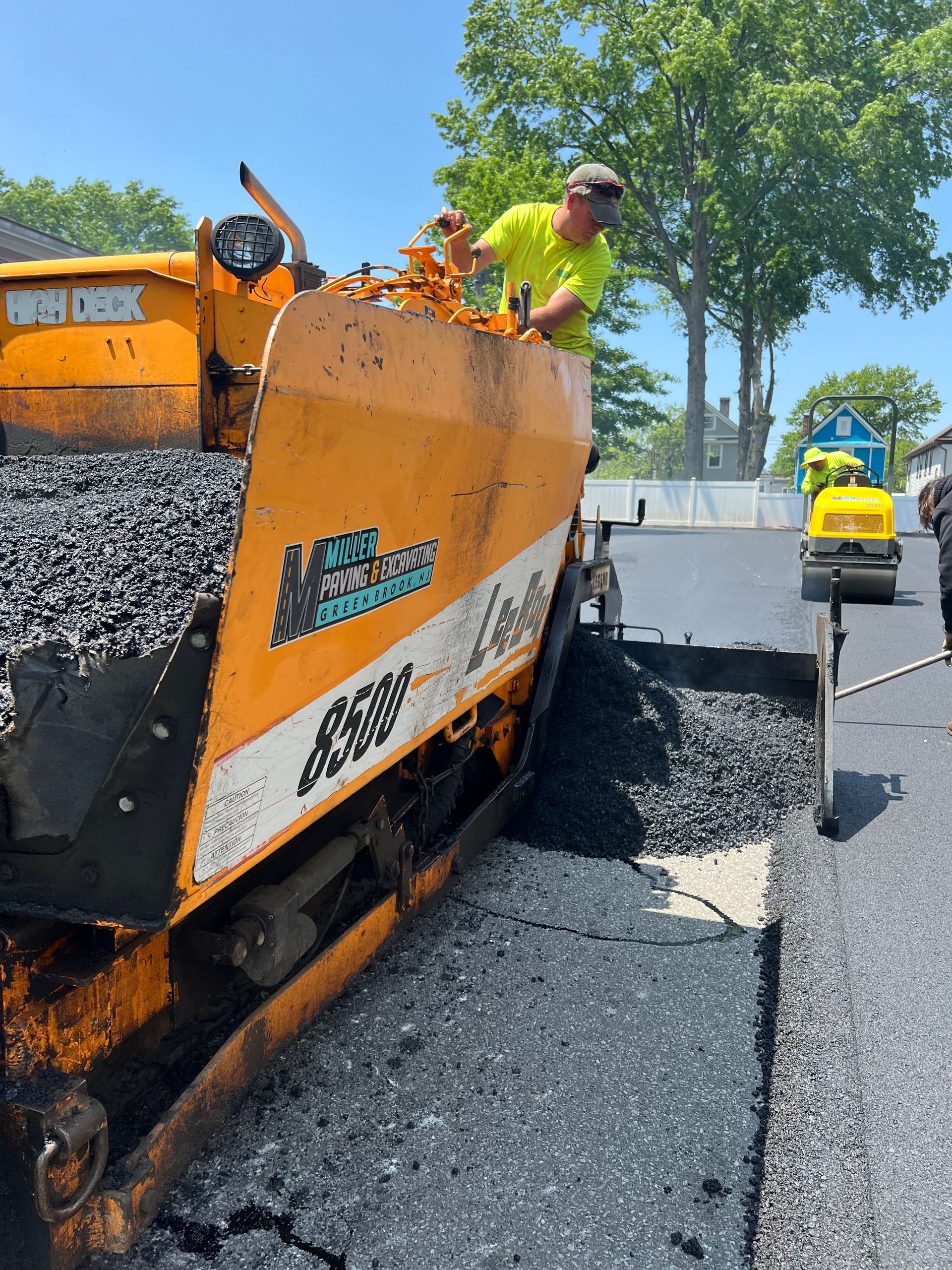 A man is working on an asphalt paving machine