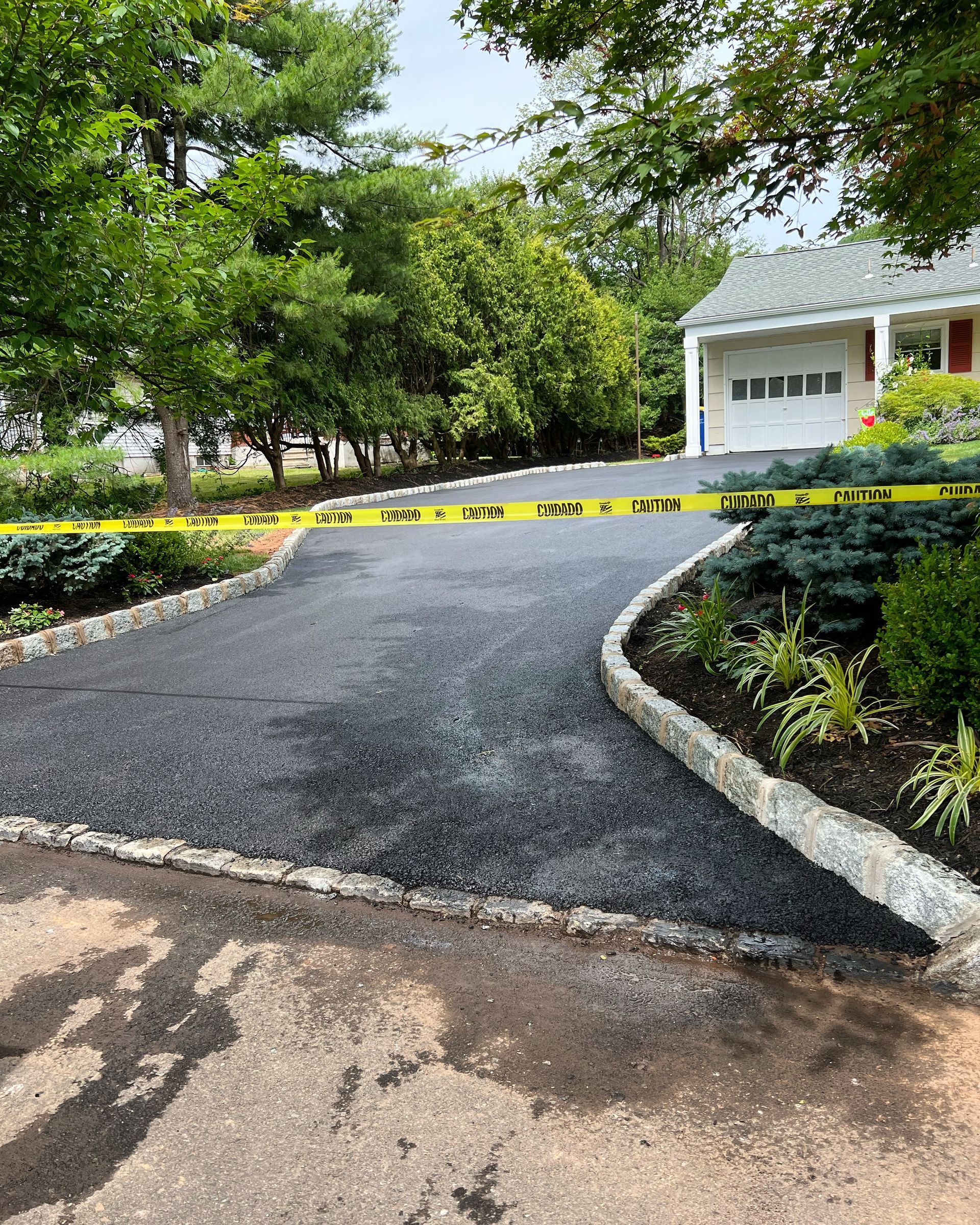 A driveway leading to a house with a yellow tape covering it.