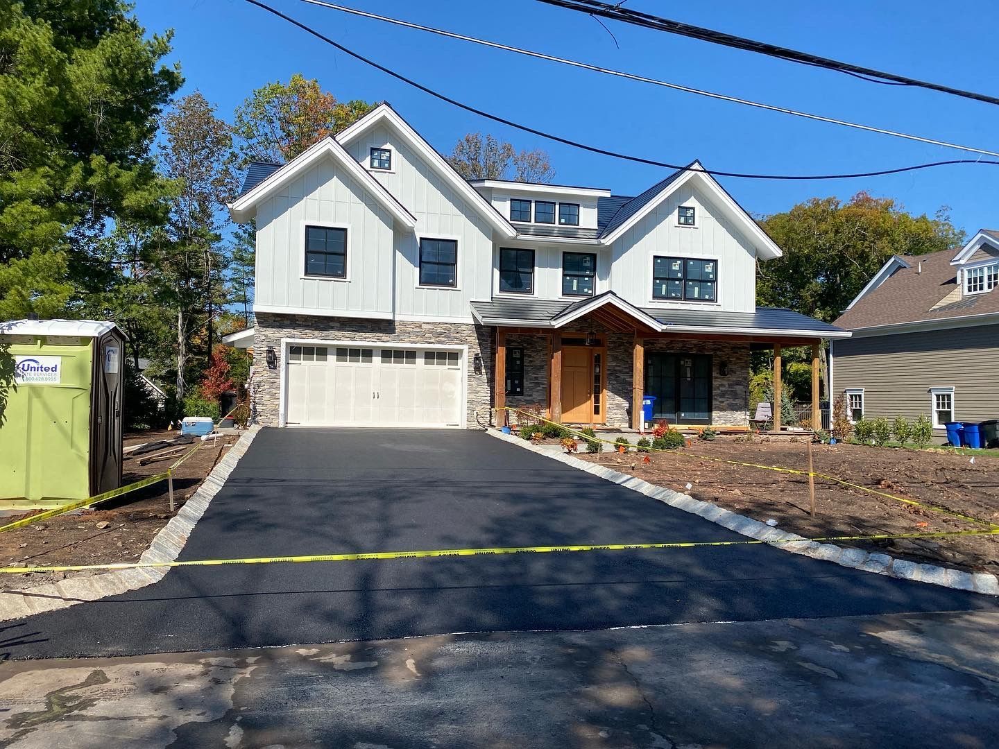 A large white house with a black driveway in front of it.