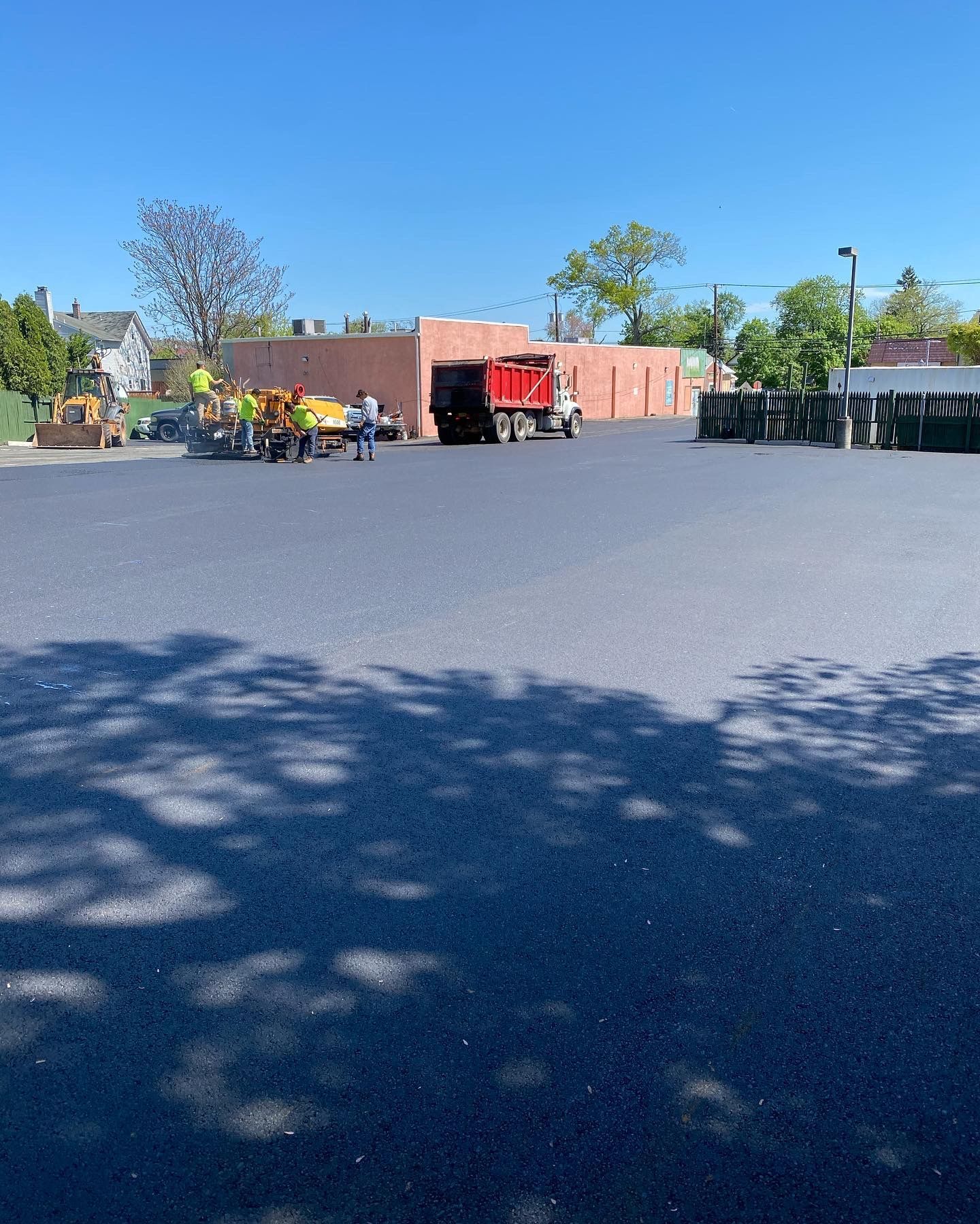 A dump truck is parked in a parking lot next to a building.