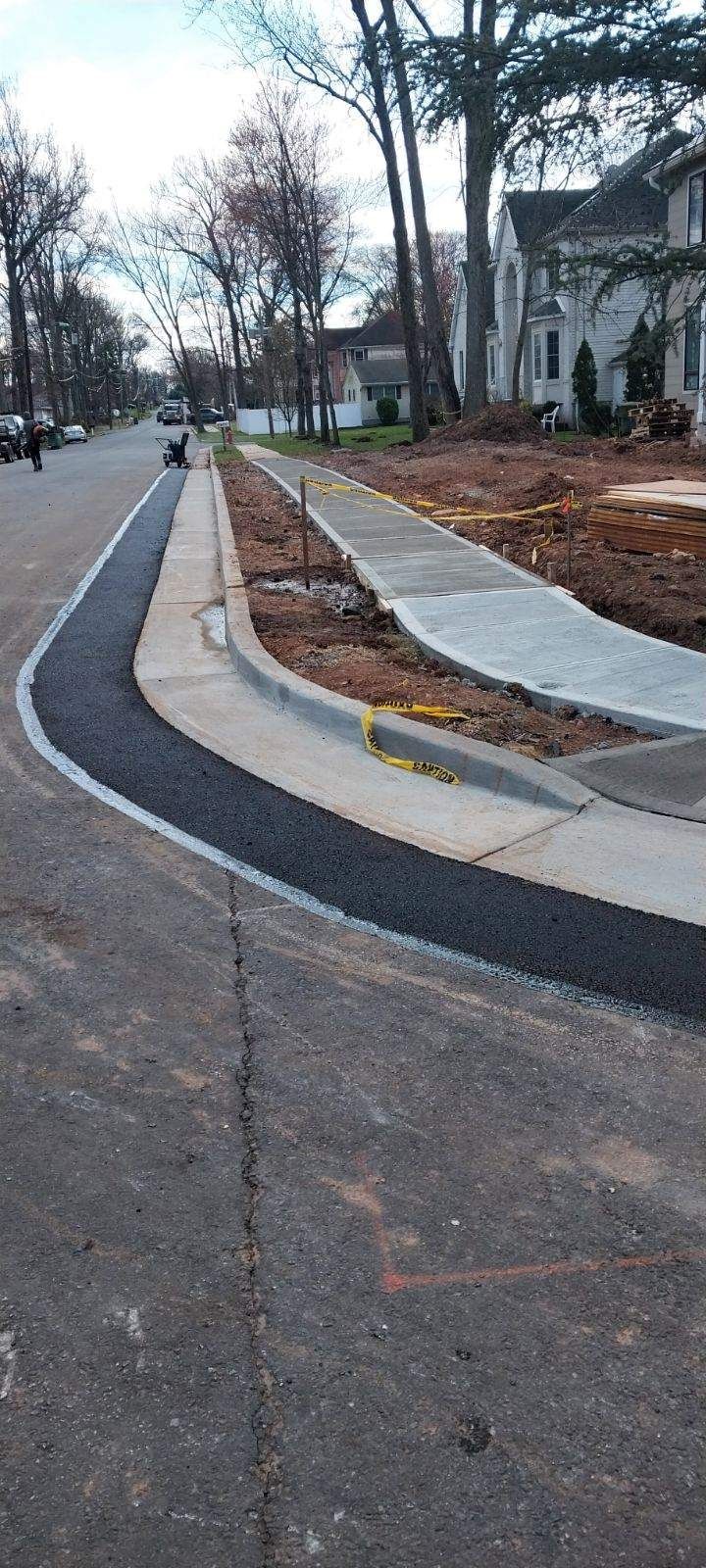 A sidewalk is being built on the side of a road.