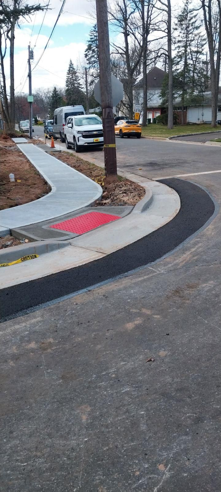 A row of cars are parked on the side of a street.