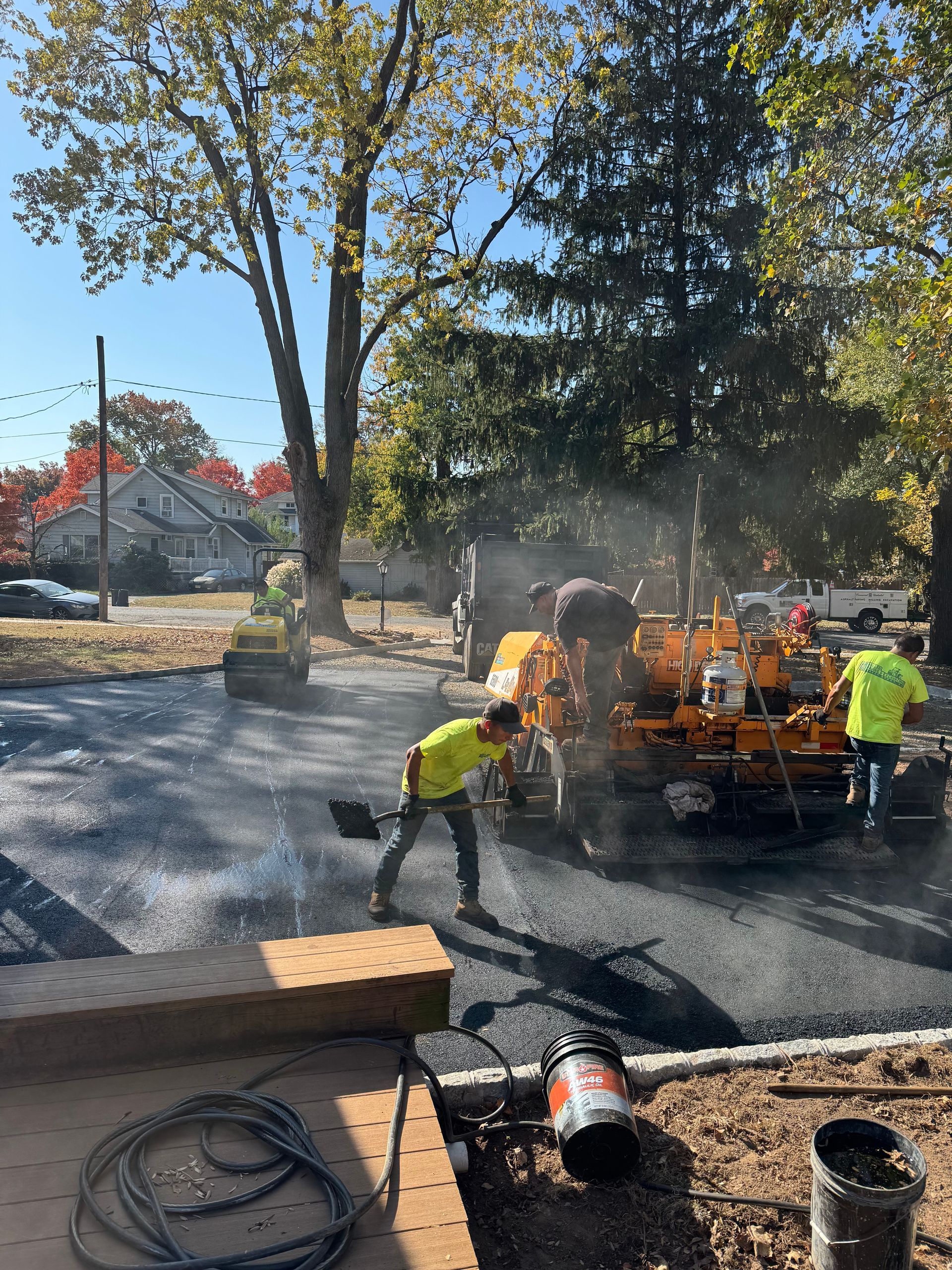 A group of construction workers are working on a driveway.