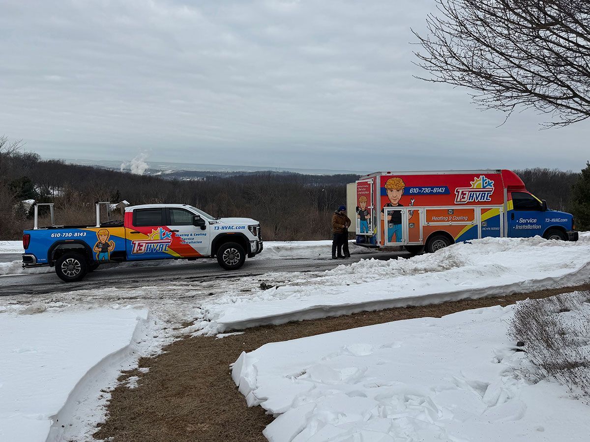 A pickup truck and a branded mobile food trailer parked in a snowy landscape with trees in the background.