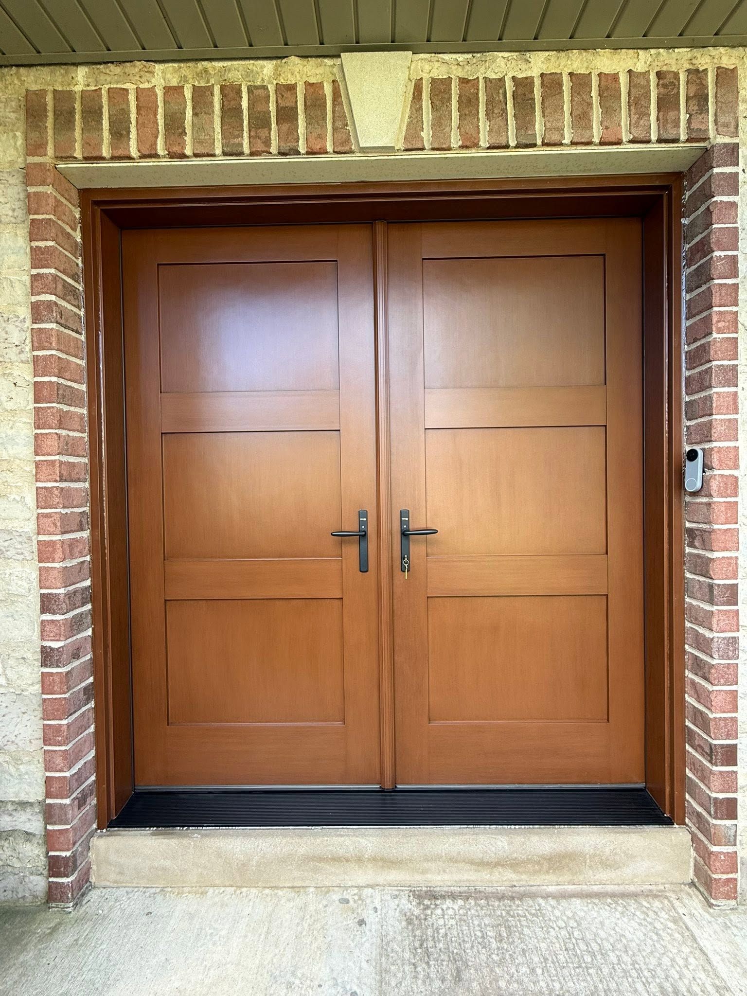 Closed wooden double doors in a brick entryway