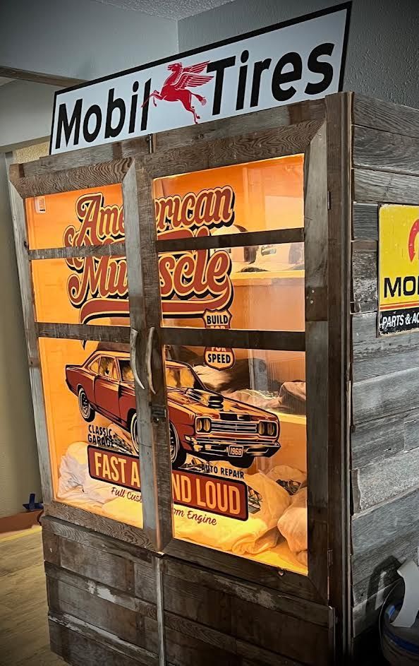 A wooden cabinet with a sign that says Mobil tires on it.