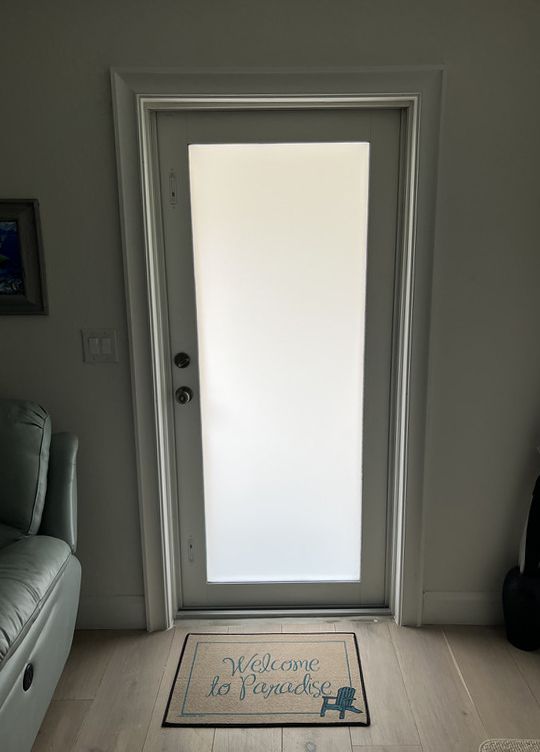 White door with frosted glass, doormat 