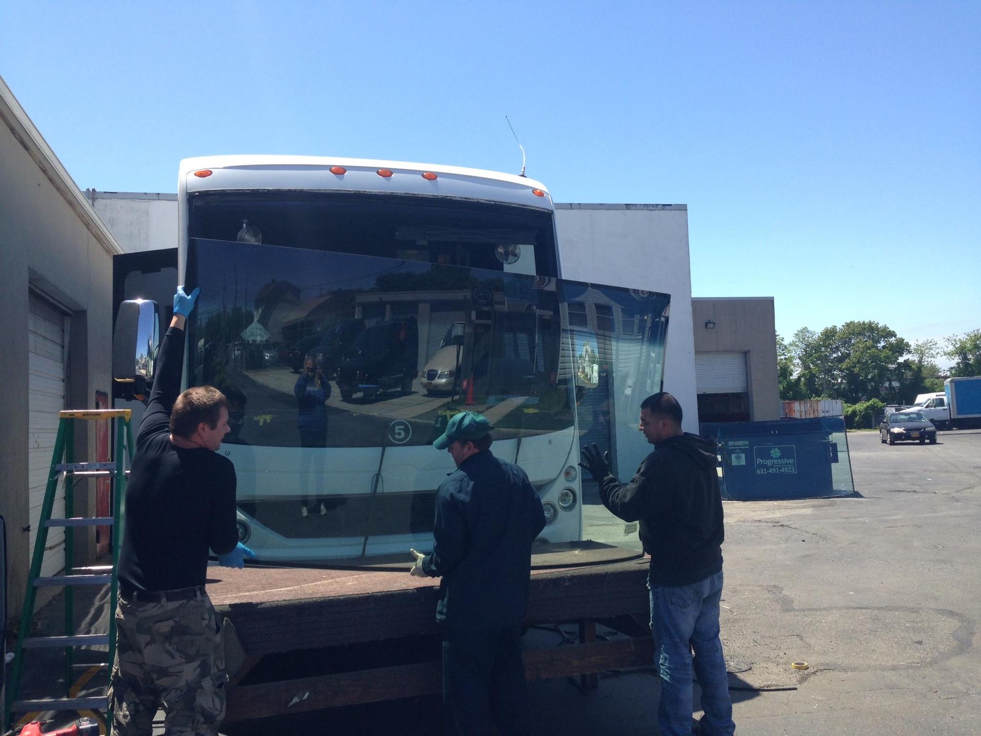 a group of men are working on a bus in a parking lot