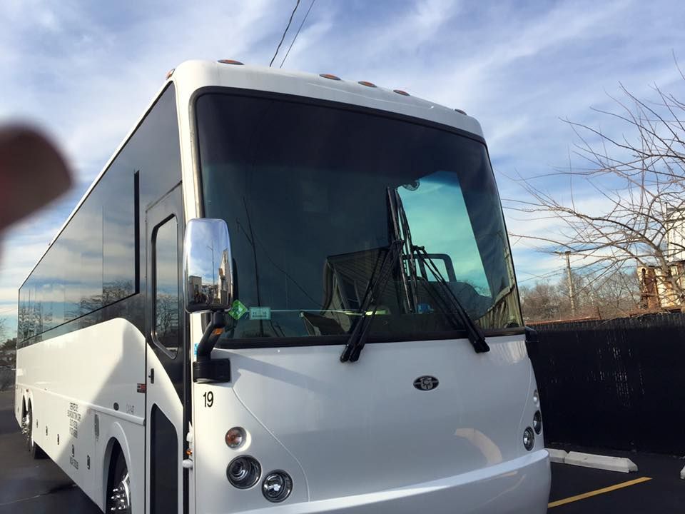a large white bus is parked in a parking lot