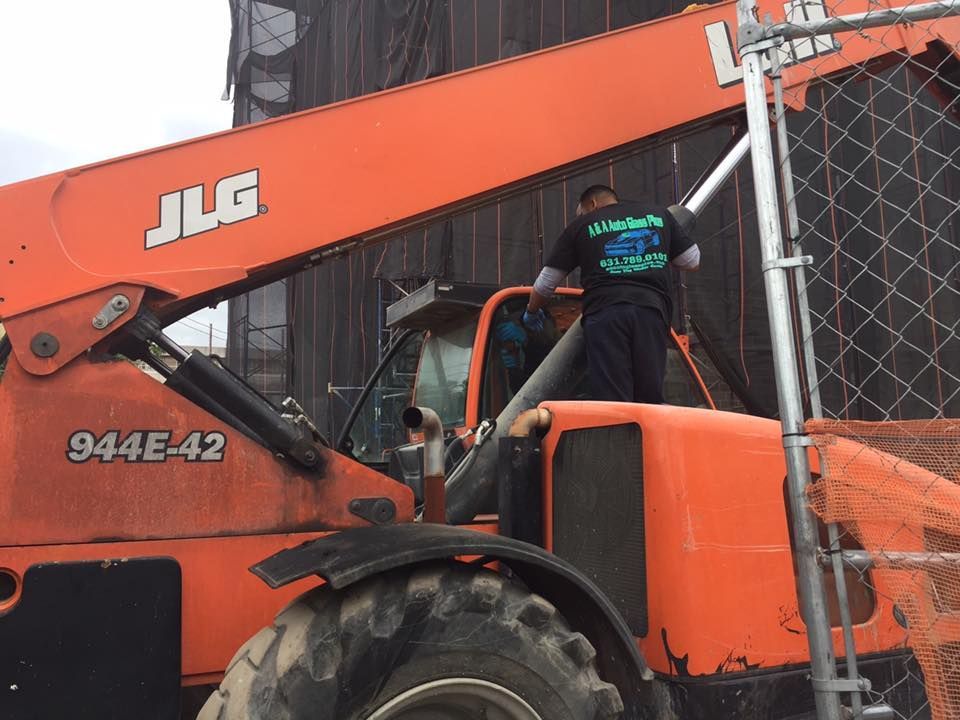 a man is standing on top of an orange crane