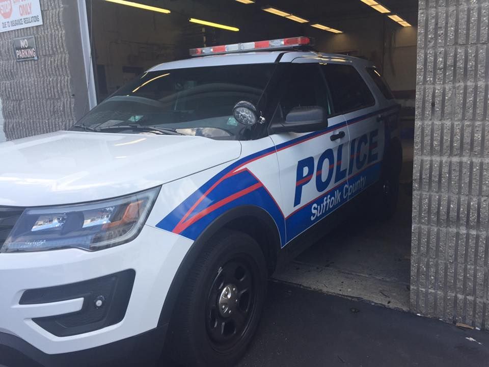 a white and blue police car is parked in a garage