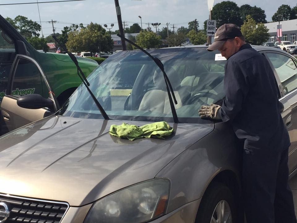 a man is cleaning the windshield of a car