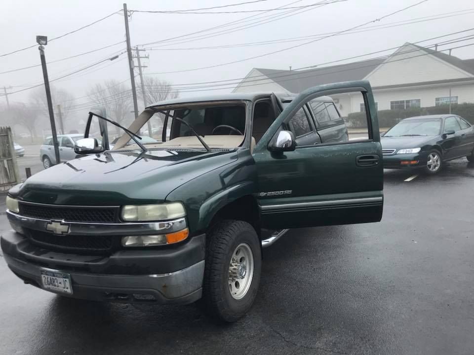 a green Chevrolet truck is parked in a parking lot with its doors open