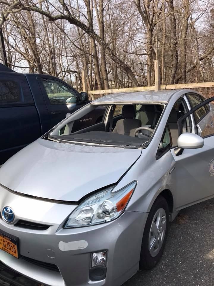 a silver Toyota Prius is parked next to a black truck