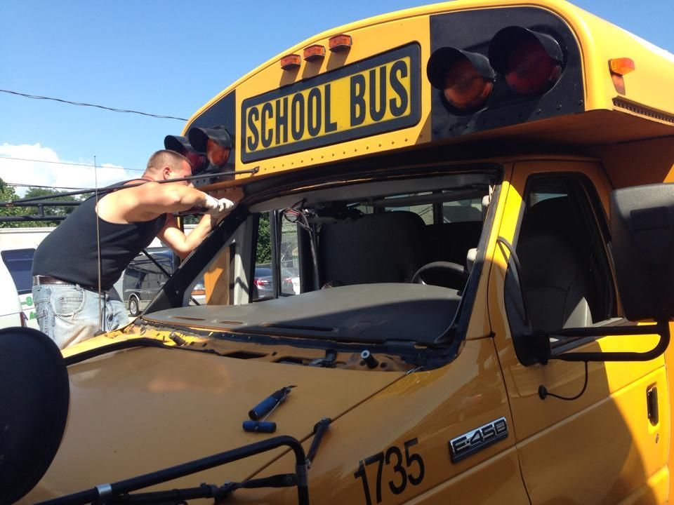 two men are working on a yellow school bus