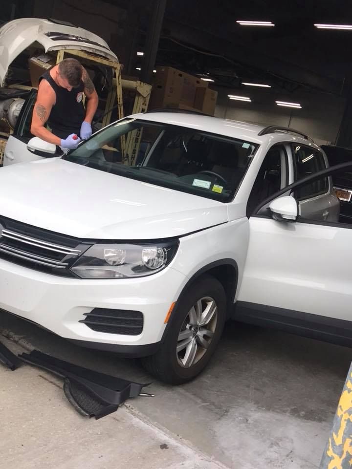 a man is working on a white car in a garage