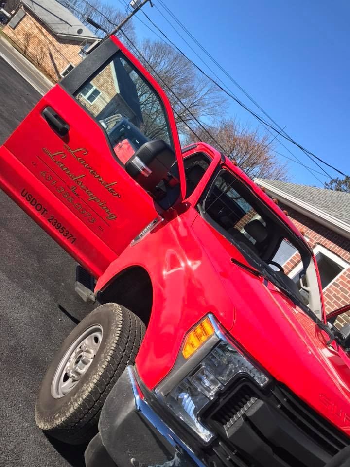 a red truck with the door open is parked on the side of the road