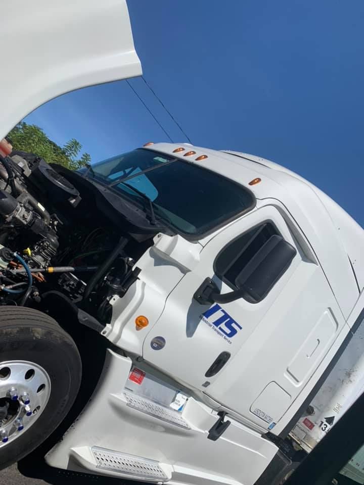 a white semi truck with its hood up is parked on the side of the road