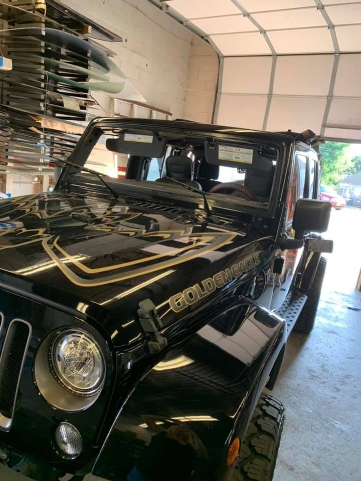 a black jeep is parked in a garage next to a garage door