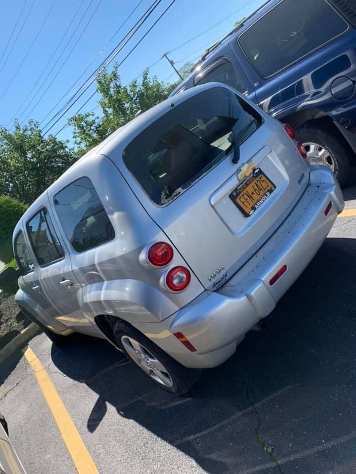 a silver car with a new york license plate is parked in a parking lot