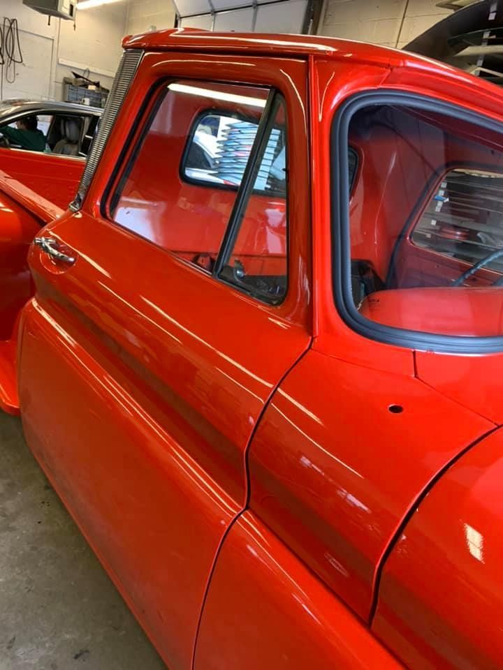 a red pickup truck is parked in a garage