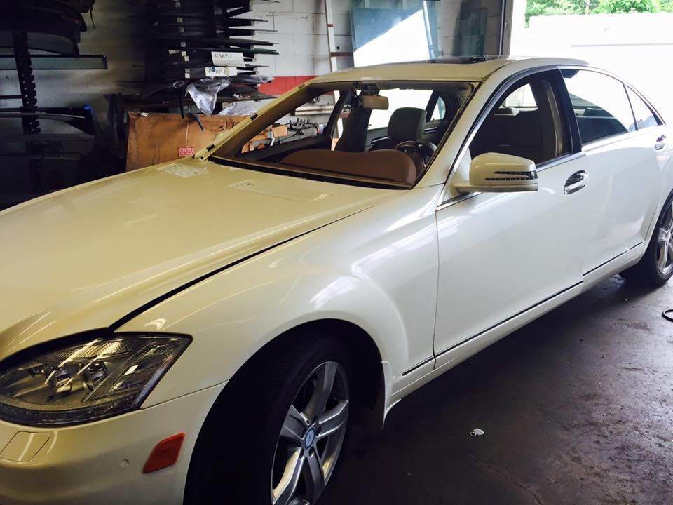 a white Mercedes Benz is parked in a garage